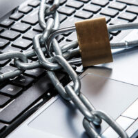 Padlock and chain on keyboard Protecting Your Online Identity